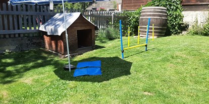 Hundehotel - Terrasse - Der Garten gut eingezäunt mit Hunderhütte und Spielelandschaft  - Ferienhaus Harmonie