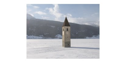 Hundehotel - Bademöglichkeit für Hunde - Italien - Kirchturm im gefrorenen Reschensee - Hotel Reschnerhof