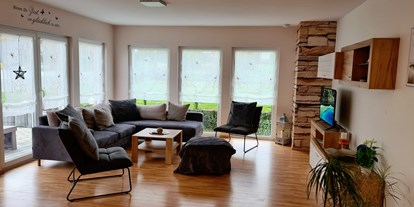 Hundehotel - Unterkunftsart: Chalet - Wohnzimmer mit Terrasse und Garten, Gartenblick  - Monteur- und Ferienwohnung Gästehaus Rhein-Main Ferienwohnung