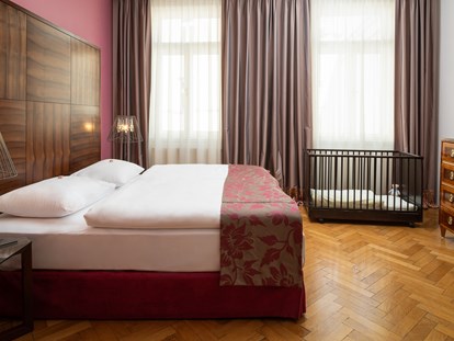 Hundehotel - keine Leinenpflicht im Hotel - Österreich - Schlafzimmer Grande Suite mit Babybett - APPARTEMENT-HOTEL AN DER RIEMERGASSE