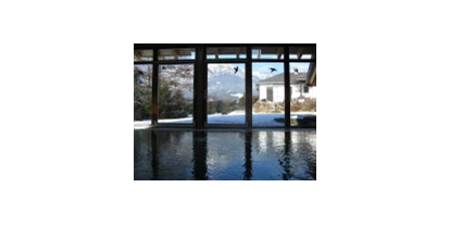 Hundehotel - Schwerpunkt: spezielle Unterkunft - Schladming-Dachstein - Sicht aus dem Schwimmbad durch das Panoramafenster auf die schneebedeckten Berge - Moser Ferienhäuser