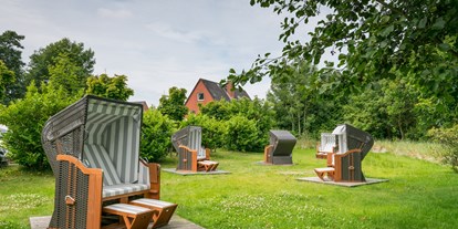 Hundehotel - Büsumer Deichhausen - Unser malerischer Wohlfühlgarten bietet viel Platz zum Verweilen. Hier entspannen Sie in unseren neuen und großen Strandkörben in ruhiger Umgebung bei einem guten Buch und lassen sich dabei von der Sonne verwöhnen. - Das Frühstückshotel SPO