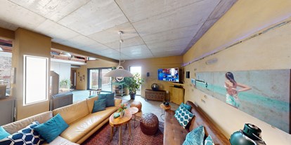 Hundehotel - PLZ 56843 (Deutschland) - Zwei Sofas vor dem großen Flat-Screen-TV mit Sky. - Maifelder Wellness-Loft mit Naturpanorama und 70 Inklusiv-Leistungen