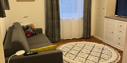 Hundehotel - Massage - Österreich - Bequemes Wohnzimmer mit 43 Zoll Smart TV, viel Stauraum - Ferienhaus Sausalblick 