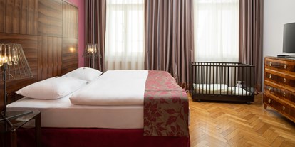 Hundehotel - keine Leinenpflicht im Hotel - Donauraum - Schlafzimmer Grande Suite mit Babybett - APPARTEMENT-HOTEL AN DER RIEMERGASSE