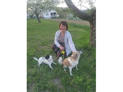 Hundehotel - Umgebungsschwerpunkt: Fluss - Übersbach - Pamela mit Ihren beiden Hündinnen Tiffy und Coco im Obstgarten - Landhaus FühlDichWohl- Boutique Hotel