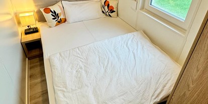 Hundehotel - Parkplatz - Österreich - Das Schlafzimmer 2 kann entweder als Queensize Bett (140 cm) oder in Form von 2 Einzelbetten (2 x 70 cm) genutzt werden. Hier kannst du das Nachtkästchen ganz einfach mittig zwischen den beiden Betten platzieren. - Blue Flamingo Lake Lodge 