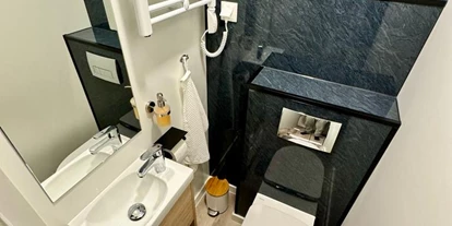 Hundehotel - Schwerpunkt: Familie - Österreich - Separates WC mit Handwaschbecken und einem Heizkörper für Handtücher. - Blue Flamingo Lake Lodge 