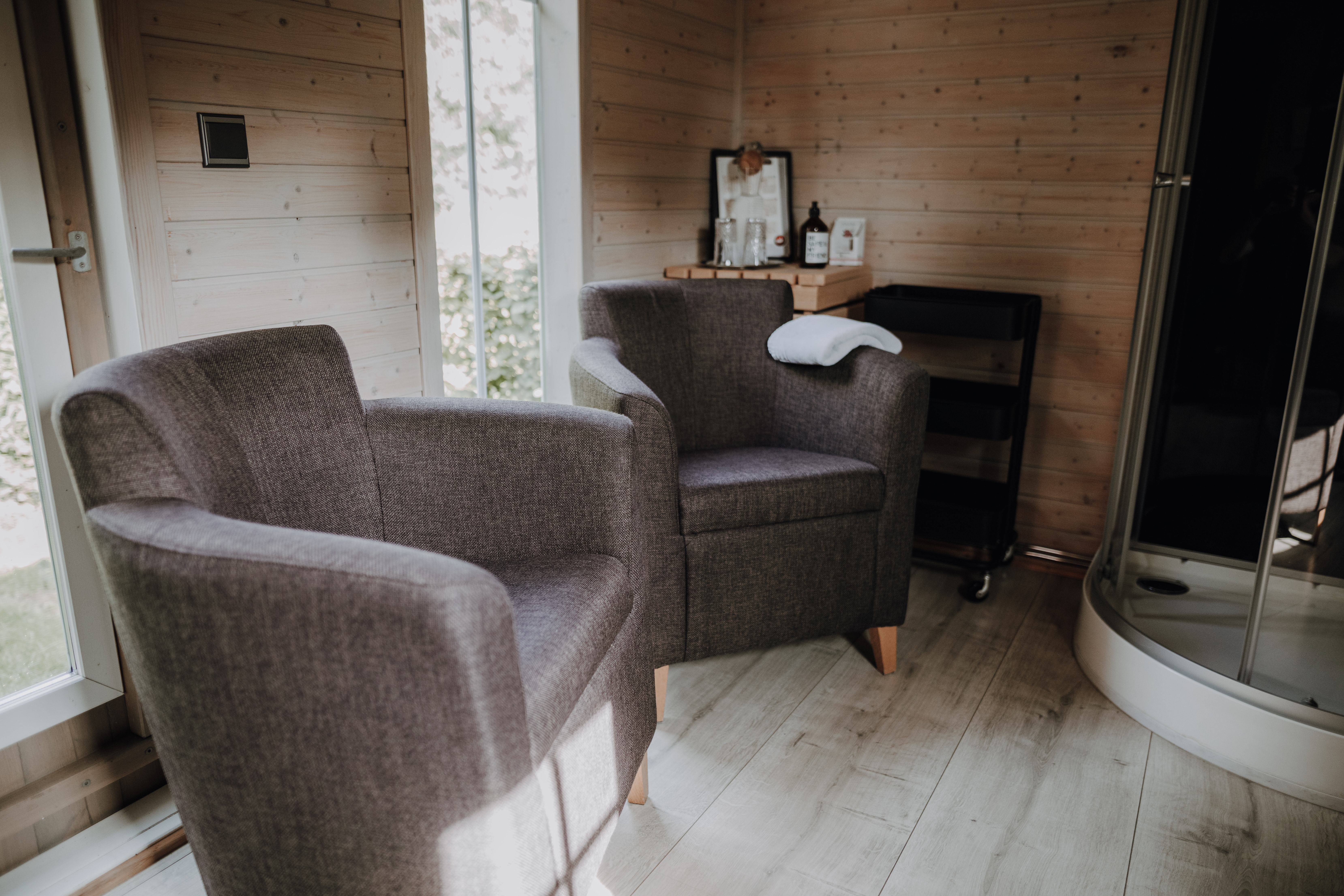 Urlaub-mit-Hund: Ruhebereich und Dusche in der Sauna - Okelmann's | Eco Hotel & Apartement - Wasser | Wellness