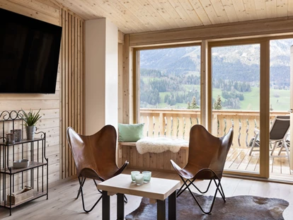 Hundehotel - Tauplitz - Wohnbereich mit Zugang zum Balkon und Blick ins Grüne - Ferienhäuser Gerhart