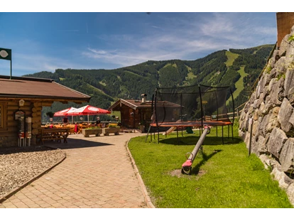 Hundehotel - Pools: Schwimmteich - Spielplatz mit Trampolin neben der Terrasse - Berghotel Jaga Alm