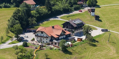 Hundehotel - Doggies: 3 Doggies - Sankt Martin am Tennengebirge - Luftaufnahme des Hotel-Gasthof am Riedl mit Haupthaus (rotes Dach) und Nebenhaus (braunes Dach) - Hotel-Gasthof Am Riedl GmbH
