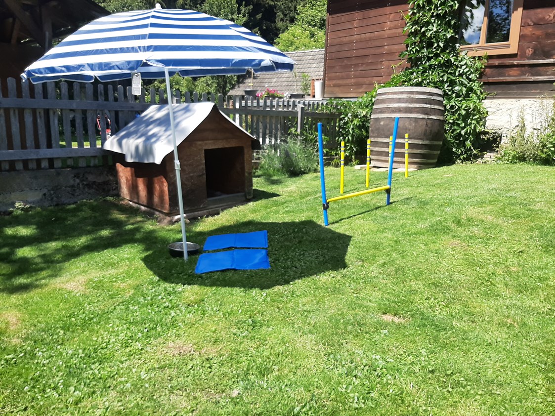 Ferienhaus mit Hund: Der Garten gut eingezäunt mit Hunderhütte und Spielelandschaft  - Ferienhaus Harmonie
