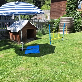 Ferienhaus mit Hund: Der Garten gut eingezäunt mit Hunderhütte und Spielelandschaft  - Ferienhaus Harmonie