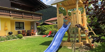Hundehotel - Tauplitz - Gartenbereich Appartement Kachelofenzauber im Erdgeschoss, eingezäunter Gartenbereich, Spielturm, Liegen, Griller, Sandkiste - Appartement Mama