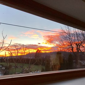 Ferienhaus mit Hund: Sonnenuntergang beobachtet durch das Wohnzimmerfenster - Ferienhaus Sausalblick 