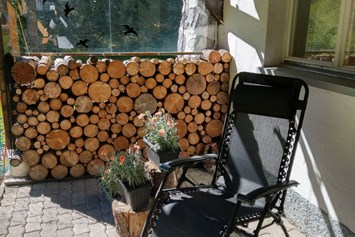 Ferienhaus mit Hund: Überdeckte Terrasse mit Essbereich und Liegestuhl - Ferienwohnung "In da Brünst"