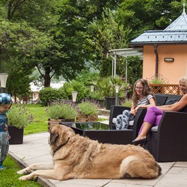 Urlaub-mit-Hund: Die Terrasse unserer selbstbedienungs Caféteria lädt zum verweilen ein und die Hunde können derweil im eingezäunten Garten spielen und toben.  - GRUBERS Hotel Apartments Gastein