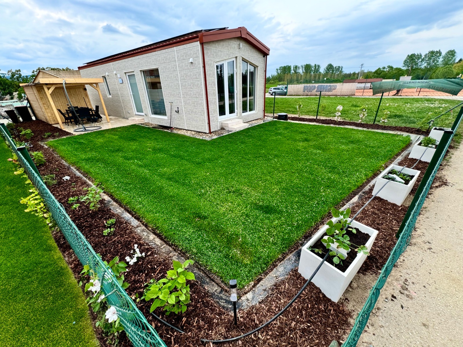 Hundehotel - Sitzplatz im Garten - In unserem 110m² großen umzäunten Garten mit überdachter Terrasse und Essbereich für 4 Personen sowie einem gemütlichen Hängesessel könnt ihr die burgenländische Sonne genießen. Ebenso stehen Sonnenliegen, Griller und mehr zur freien Verfügung. - Blue Flamingo Lake Lodge 