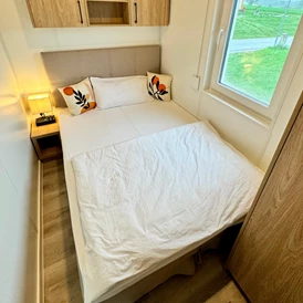 Ferienhaus mit Hund: Das Schlafzimmer 2 kann entweder als Queensize Bett (140 cm) oder in Form von 2 Einzelbetten (2 x 70 cm) genutzt werden. Hier kannst du das Nachtkästchen ganz einfach mittig zwischen den beiden Betten platzieren. - Blue Flamingo Lake Lodge 