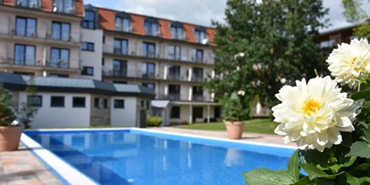 Hundehotel - Ladestation Elektroauto - Dipperz - Außenpool mit Hotelansicht - Wellness- und Tagungshotel AQUALUX