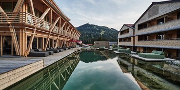 Hundehotel - PLZ 6580 (Österreich) - Außenbereich des Hotel HUBERTUS und seinem Wellnessbereich Mountain Spring Spa mit NaturBadeSee - HUBERTUS MOUNTAIN REFUGIO ALLGÄU